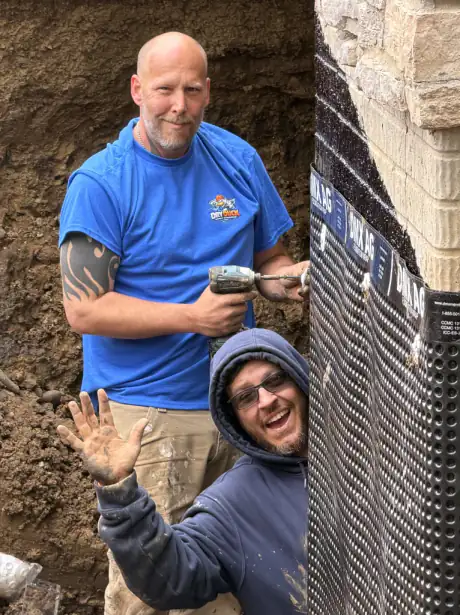 Dry Duck Basement Waterproofing crew installing DMX AG foundation wrap during exterior waterproofing in the Des Moines and central Iowa area